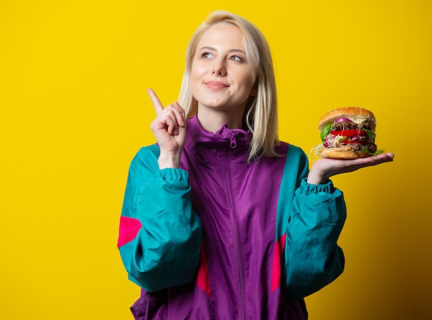 Girl in 80s clothes style with burger