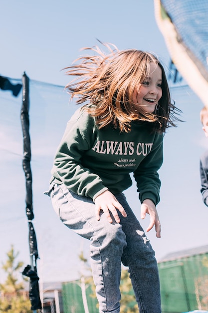 Girl 89 years jumping in trampoline in the park children\'s\
leisure cooutdoors lifestyle concept