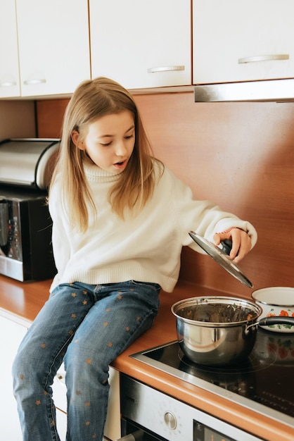 girl 9 years old with long hair model schoolgirl at home lifestyle in a beige kitchen