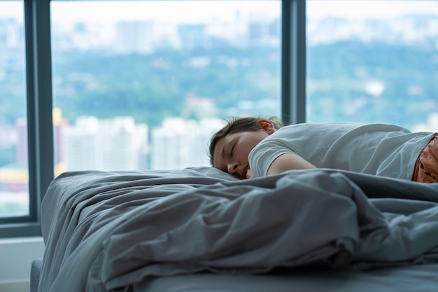 その少女は正午にうっかりベッドで眠りに落ちた。女の子は午後に服を着て寝ます。短い回復的な日中の睡眠。