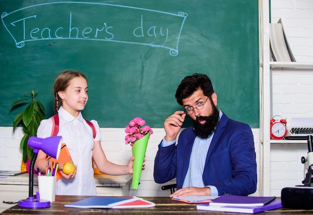 Girl adorable pupil with backpack carry bouquet flowers for teacher Back to school Knowledge day congratulations School holiday September 1 Thankful schoolgirl Greetings for school pedagogue