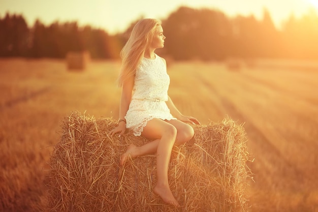 взрослая девушка в овсяном поле сексуальная / счастливая девушка в летнем поле, блондинка с длинными волосами