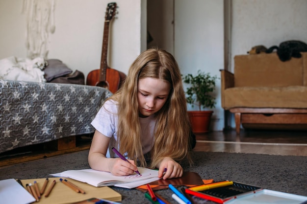 the girl after school plays at home draws with pencils and felttip pens