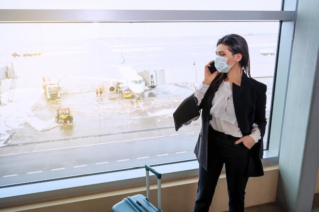 Girl at the airport window waits for a flight