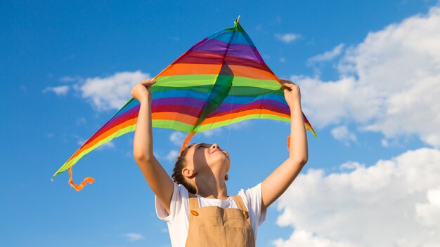 The girl alone launches multicolored kite into the sky