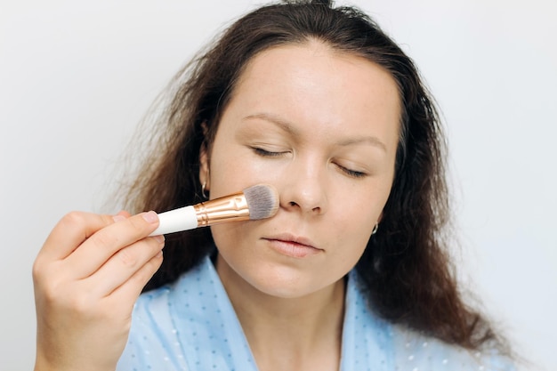 The girl applies a tonal corrective cream on a problematic pigmentation face