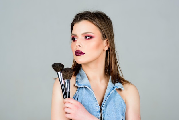 Girl apply powder eye shadows Looking good and feeling confident Makeup dark lips Attractive woman applying makeup brush Professional makeup supplies Makeup artist concept Emphasize femininity