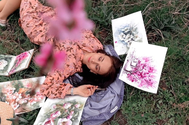 Girl artist paints a peach orchard in a peach orchard spring