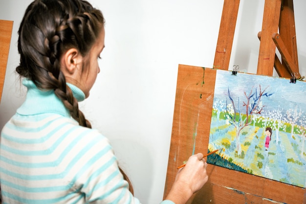 Photo girl artist writes oil painting