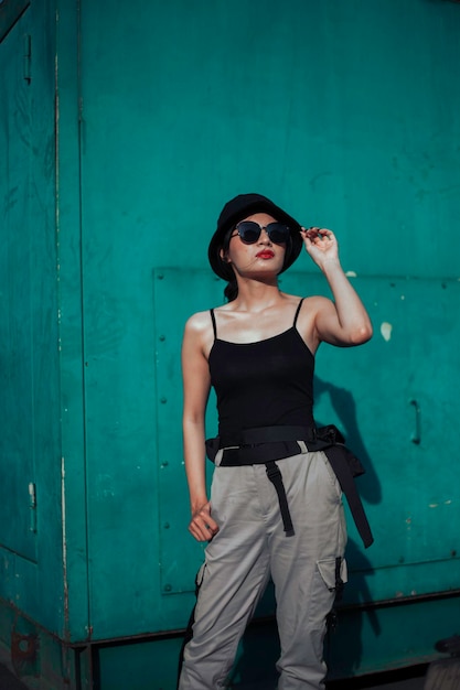 Girl asian in a light hat and sunglasses on a summer day