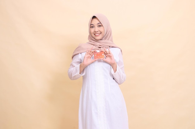 girl asian muslim in hijab smiling cheerfully holding debit credit card in both hands Lifestyle busi