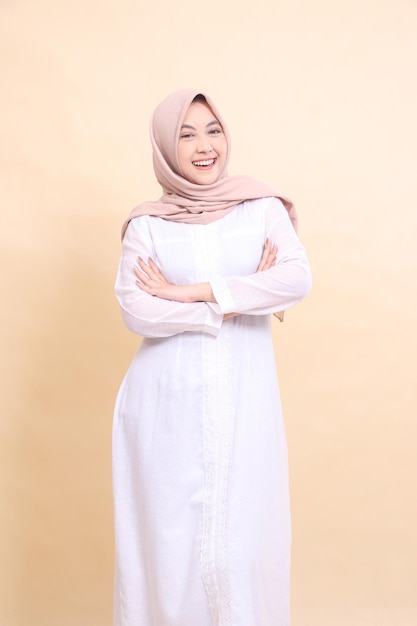 girl asian wearing beautiful Muslim dress happy holding arms isolated on cream background beauty mod