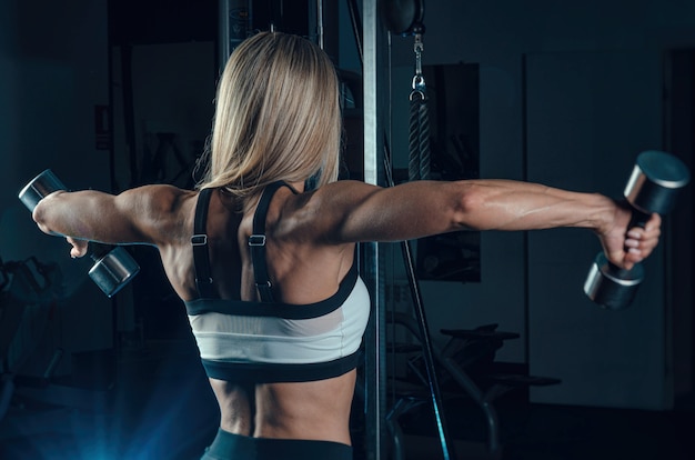 L'atleta ragazza in abbigliamento sportivo si sta allenando in palestra