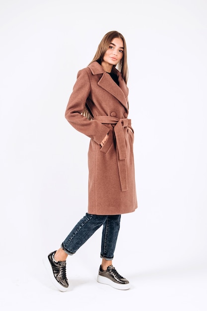 Girl in autumn coat on a white background