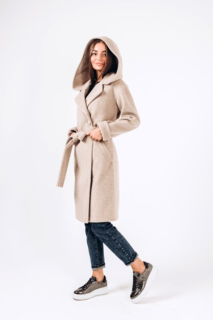 Girl in autumn coat on a white background