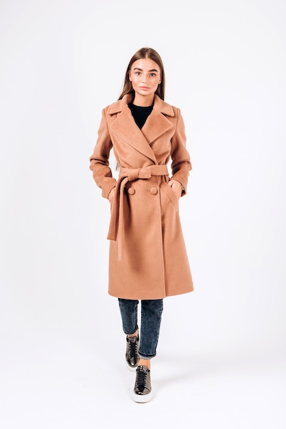 Girl in autumn coat on a white background