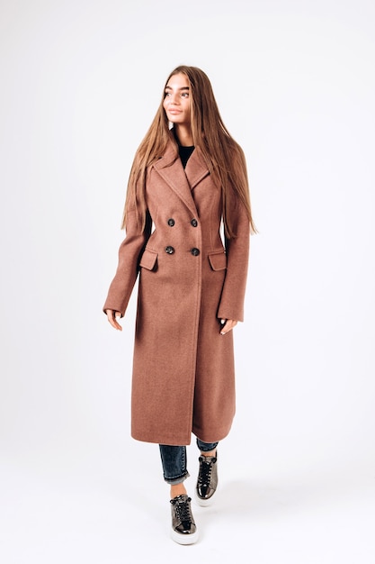 Girl in autumn coat on a white background