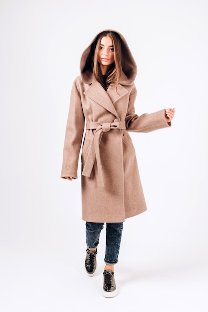 Girl in autumn coat on a white background