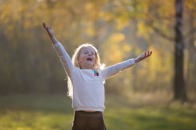 가을 공원의 소녀가 단풍잎을 흩뿌리다 가을에 산책을 하는 아이