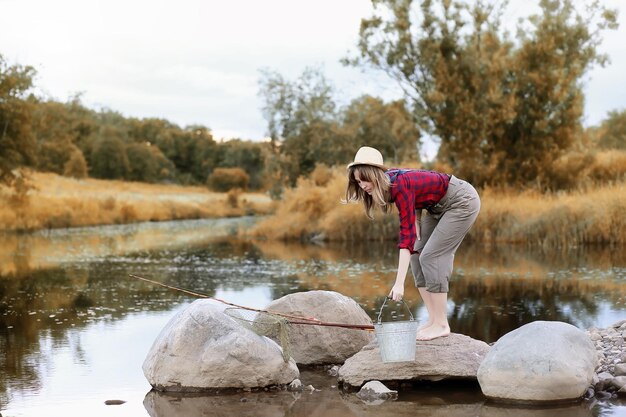 Girl in autumn with a fishing rod