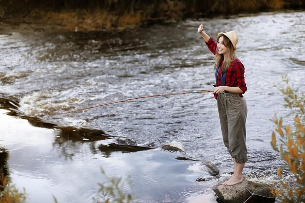 Girl in autumn with a fishing rod