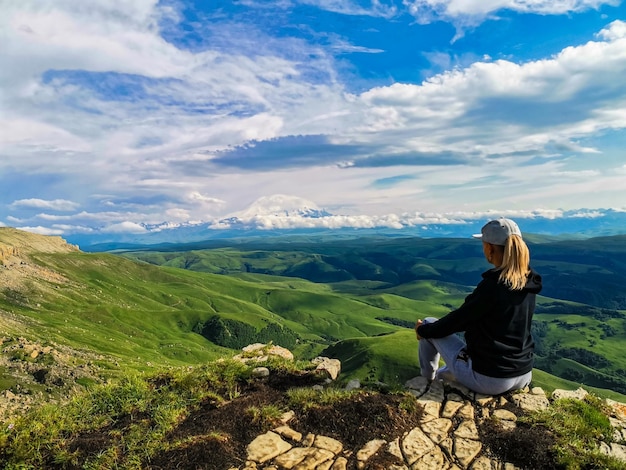 A girl on the background of the mountains and the Bermamyt plateau in Russia June 2021