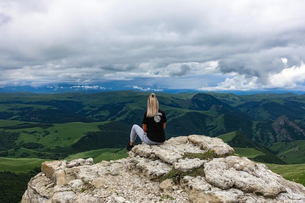 A girl on the background of the mountains and the Bermamyt plateau in Russia June 2021