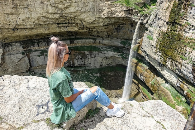 トボットの滝の背景にある女の子クンザフの滝ダゲスタンロシア2021