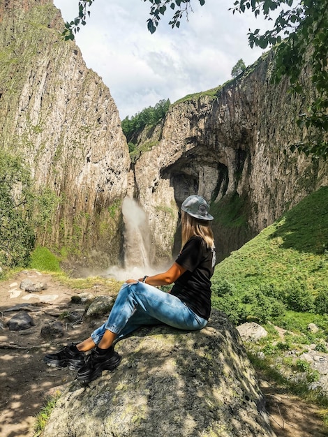 A girl on the background of the TuzlukShapa waterfall on the territory of KabardinoBalkaria Caucasus Russia