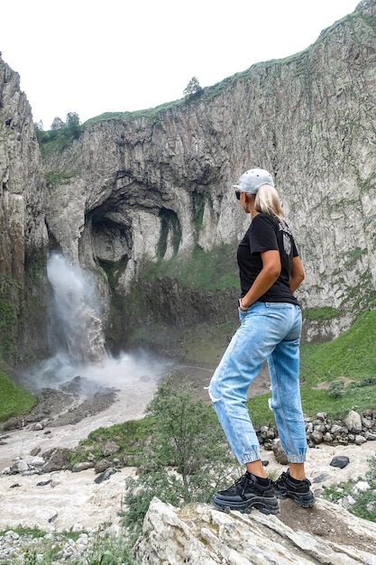 KabardinoBalkaria Caucasus 영토에 있는 TuzlukShapa 폭포 배경에 있는 소녀