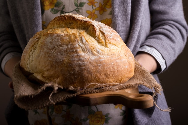 Girl baker holding fresh white bread