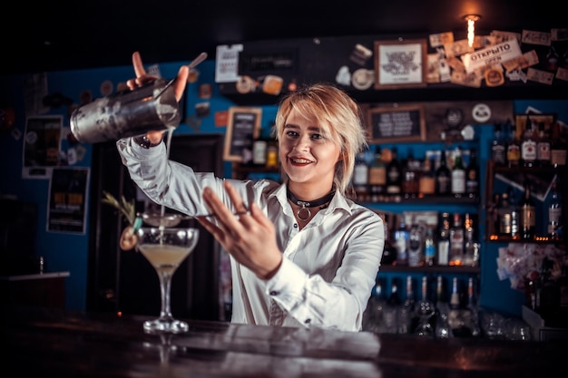 Girl barman concocts a cocktail on the taproom