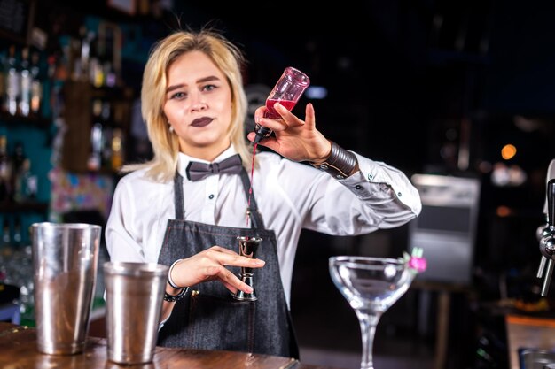 Photo girl barman creates a cocktail in the alehouse