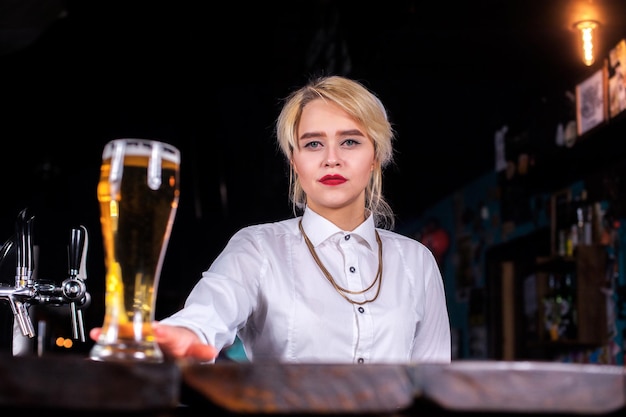 Girl barman formulates a cocktail on the alehouse