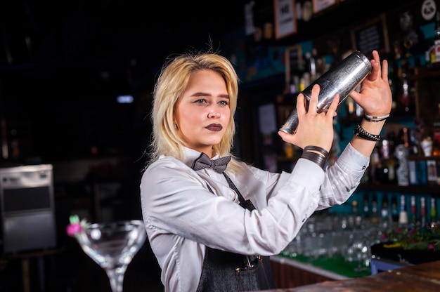 Девушка-бармен готовит коктейль в пивной