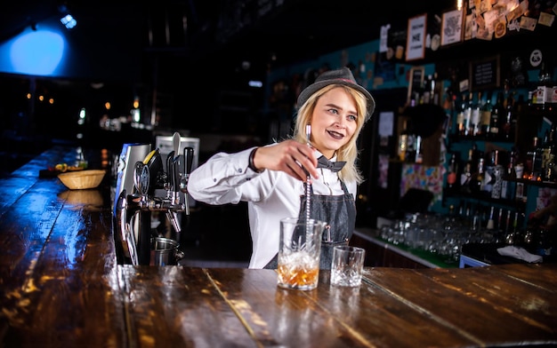 Photo girl barman formulates a cocktail at the pothouse