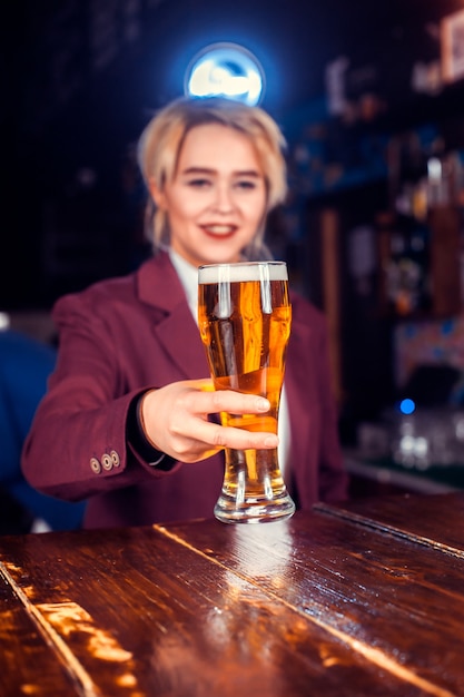 Girl barman formulates a cocktail in the saloon