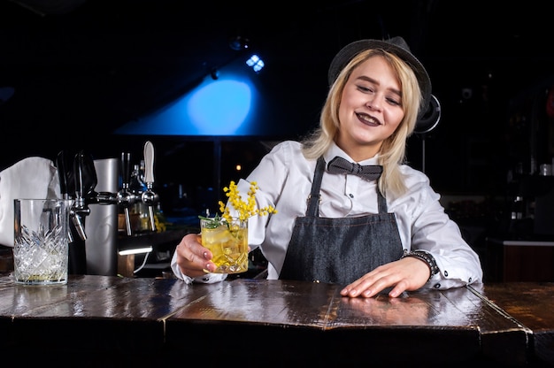 Girl barman makes a cocktail at the brasserie