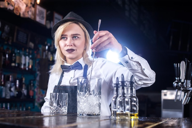 Girl barman makes a cocktail in the porterhouse