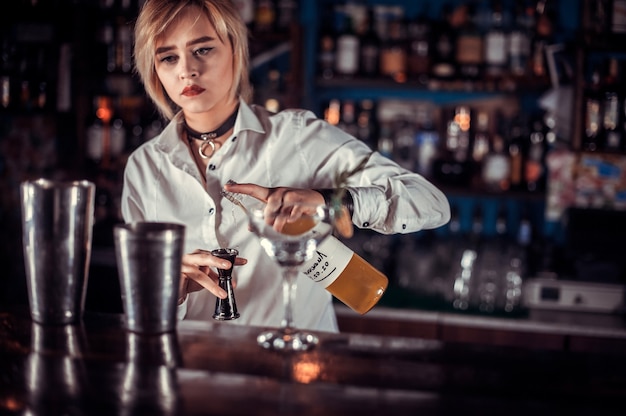 Girl bartender creates a cocktail on the public house