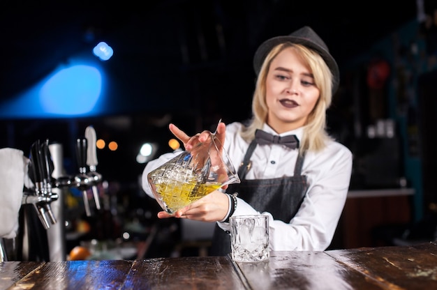 Il barista della ragazza crea un cocktail nella sala pubblica