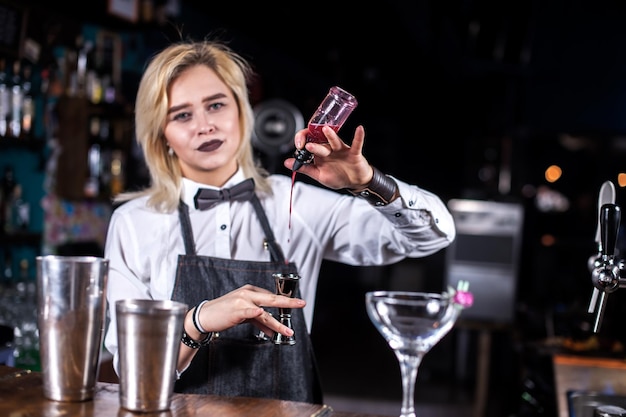 Girl bartender makes a cocktail on the porterhouse