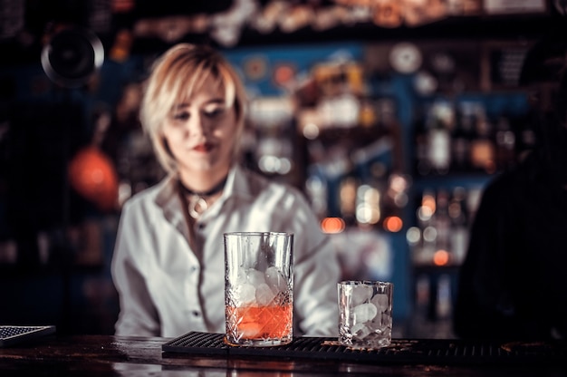 Girl bartender mixes a cocktail at the alehouse