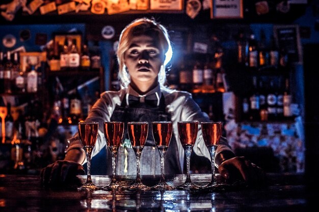 Girl bartender mixes a cocktail in the saloon