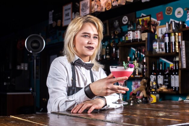 Girl bartender mixes a cocktail at the taproom