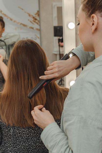 Girl in beauty salon is doing her hair women39s hair styling on
flat iron blog aesthetics beauty hair stylists hair curling curling
iron space for text