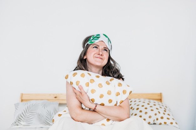 Foto la ragazza a letto si è svegliata, dormi, mattina, procedure mattutine, colazione, cuscino, maschera per dormire, mani