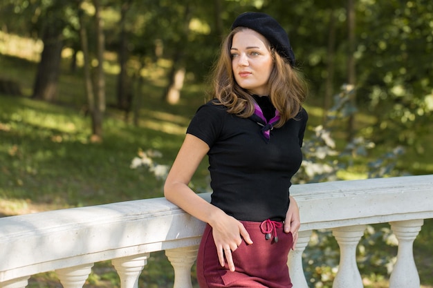 The girl in beret and skirt in the park