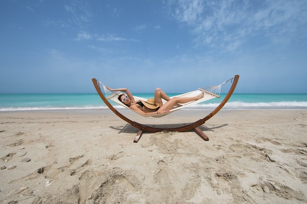 Foto ragazza in bikini che riposa su un lettino prendisole