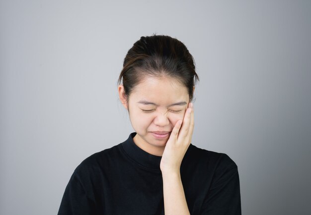 girl in black casual dress Show off toothache, Maybe because of not maintaining.